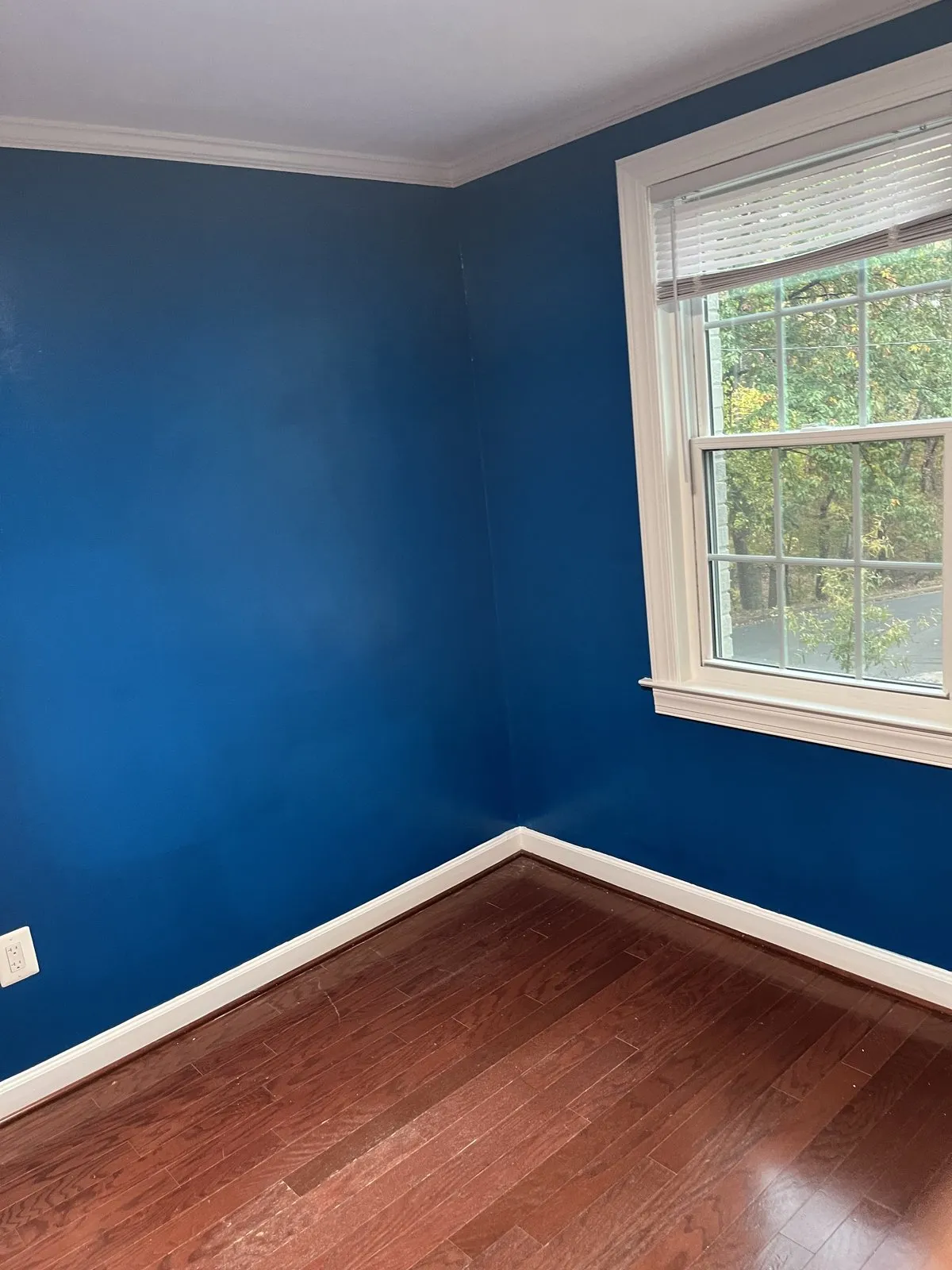 Bedroom interior repainted in soft blue with white trim