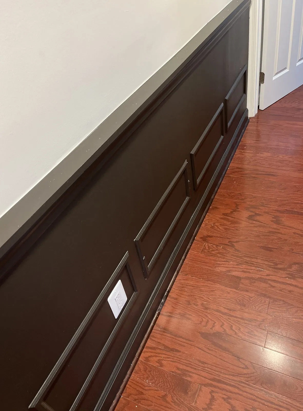 Detail of installed wainscoting and trim work in a hallway